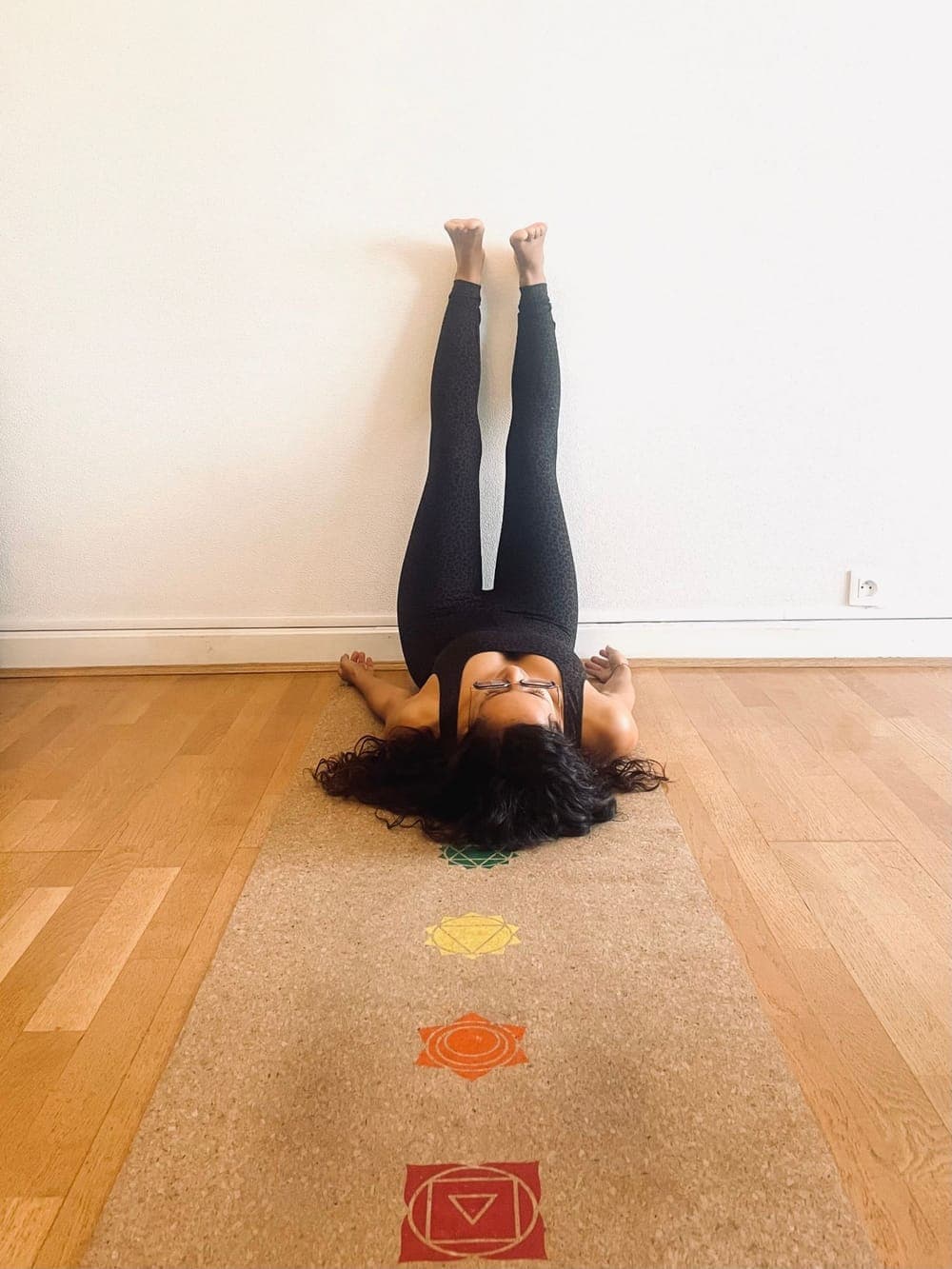 Anaïs en Viparita Karani, allongée sur le dos, les jambes tendues contre le mur