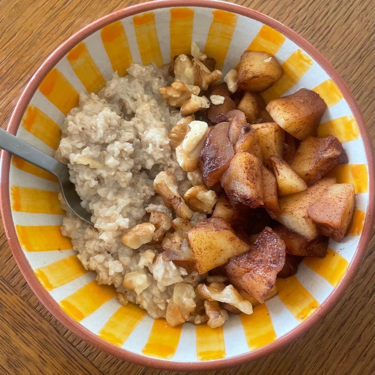 Un bol de porridge aux pommes cuites à la cannelle et aux noix, préparé par Anaïs